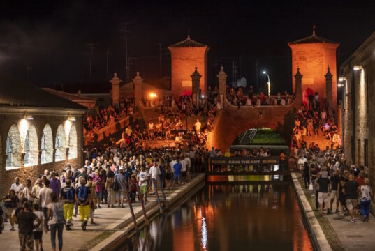 Sommerliche Festivalstimmung in Comacchio: Entlang der beleuchteten Kanäle wird die Altstadt zur Bühne für Musik, Begegnung und mediterranes Lebensgefühl. (Foto: © Elisa Catozzi Photography)