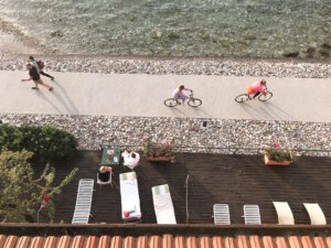 Radfahrer auf einem Uferweg am Gardasee, flache, gut ausgebaute Strecken machen die Region besonders für Familien und Genussradler attraktiv. (Foto: © Lago di Garda Camping)