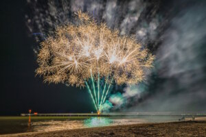 Sommernacht an den Lidi di Comacchio: Ein Feuerwerk über dem Meer taucht Strand und Steg in leuchtende Farben. (Foto: © Valentina Tomasi)