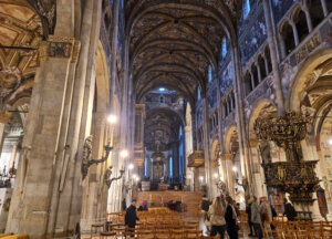 Blick durch das Langhaus des Doms von Parma mit romanischer Architektur und späteren Freskenzyklen aus dem 16. Jahrhundert, die den ursprünglich schlichten Innenraum überformen. (Foto: © Bastian Glumm)