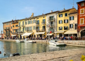 Die malerische Hafenpromenade von Lazise: bunte Häuser, Cafés und Boote prägen das mediterrane Flair. (Foto: © Lago di Garda Camping)