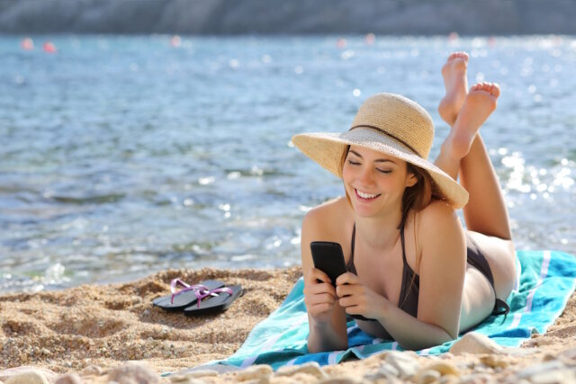 Es könnte so schön einfach sein: ein Smartphone, ein Strand in Italien und das Geld kommt von allein. Die Realität sieht meist etwas anders aus. (Foto: © Antonioguillem / Adobe Stock)