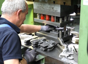 Ein Mitarbeiter bedient eine Produktionsmaschine in einem metallverarbeitenden Betrieb. Praktische Arbeit im Betrieb ist ein wichtiger Bestandteil vieler handwerklicher Ausbildungswege. (Foto: © Bastian Glumm)