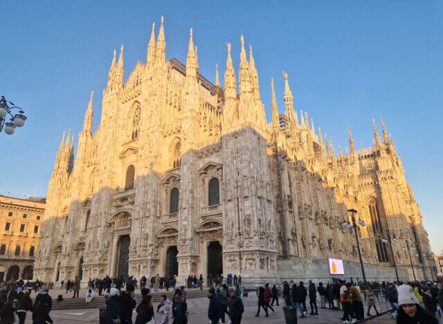 mailand-milano-dom-duomo (2) Blick auf den Dom von Mailand auf der Piazza del Duomo. Die gotische Marmorfassade im warmen Abendlicht, dicht umlagert von Besuchern während unseres ungeplanten Stopps in der Stadt.(Foto: © Bastian Glumm)