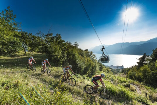 Mountainbiker auf einer Panorama-Abfahrt am Monte Baldo mit Blick auf den Gardasee. Die Region bietet ideale Bedingungen für sportliche Touren zwischen Höhenlage und Seeufer. (Foto: © Funivie del Baldo)