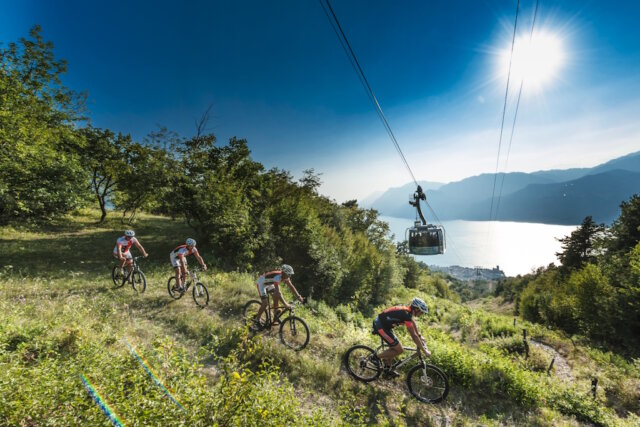 monte-baldo-gardasee-bike-fahrrad Mountainbiker auf einer Panorama-Abfahrt am Monte Baldo mit Blick auf den Gardasee. Die Region bietet ideale Bedingungen für sportliche Touren zwischen Höhenlage und Seeufer. (Foto: © Funivie del Baldo)