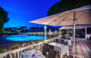 Abendstimmung am Pool des Park Hotel Marinetta in Marina di Bibbona – stilvolles Dinner unter freiem Himmel mit Blick auf das beleuchtete Wasser. (Foto: © Park Hotel Marinetta)