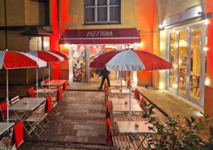 Abends vor der Pizzium-Filiale in Parma: ein paar Tische draußen, warmes Licht und genau der richtige Ort nach einem langen Tag. (Foto: © Bastian Glumm)