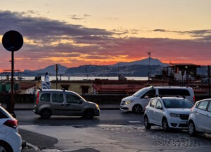 Abendverkehr in Süditalien mit Blick über den Golf von Pozzuoli: Die Mischung aus engen Straßen, dichtem Stadtverkehr und vielen Pendlern zeigt, warum die Kfz-Versicherung in Italien 2025 stark von regionalen Bedingungen und unterschiedlichen Risikozonen geprägt ist. (Foto: © Bastian Glumm)
