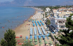 Blick auf den Strand von Sperlonga: Kilometerlange Sandküste mit bunten Sonnenschirmen und kristallklarem Meer. (Foto: © Bastian Glumm)