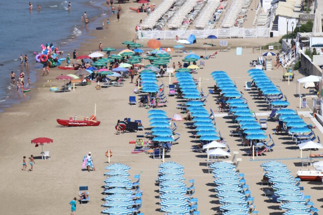 strand-liege-sonneschirm-sommer-urlaub Der Schatten wir zunehmend teurer und Ordnung trifft Urlaub – klassische Reihen mit Sonnenschirmen und Liegen an einem italienischen Strand zeigen, wie stark der Platz am Meer reglementiert und kommerzialisiert ist. (Foto: © Bastian Glumm)