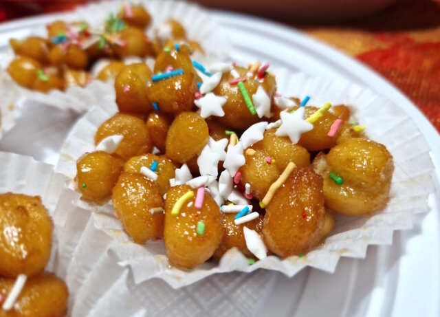 Hausgemachte Struffoli: frisch frittiert, in Honig gewendet und klassisch mit Zuckerstreuseln dekoriert. (Foto: © Bastian Glumm)