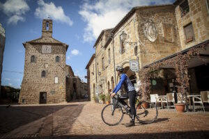 Ein Radfahrer auf einem historischen Platz: Die Toskana lässt sich im Sommer nicht nur sehen, sondern aktiv erleben: zwischen mittelalterlichen Ortskernen und entschleunigter Bewegung. (Foto: © Mariollorca.com / Toscana Promozione Turistica)
