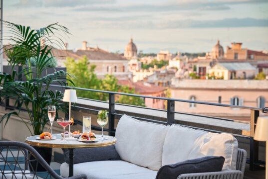 Aperitivo mit Aussicht: Von der Dachterrasse des "Trastevere Roma | UNA Esperienze" eröffnet sich im Herbst ein traumhafter Blick über die Dächer Roms. (Foto: © UNA Italian Hospitality)