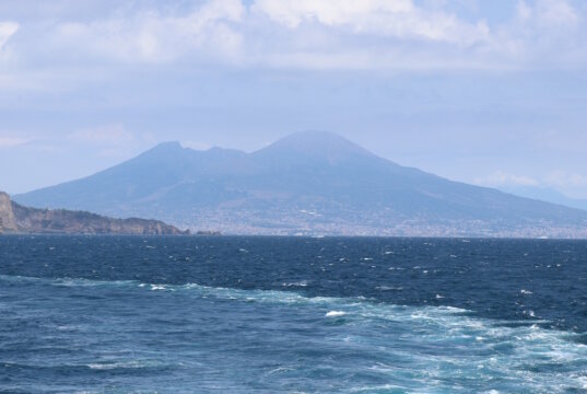 Vom offenen Meer aus zeigt sich der Vesuv in seiner ganzen Größe. Die sanft geschwungenen Flanken des Vulkans heben sich über der weitgezogenen Bucht von Neapel und schaffen ein eindrucksvolles Panorama, das Reisende schon seit Jahrhunderten fasziniert. (Foto: © Bastian Glumm)