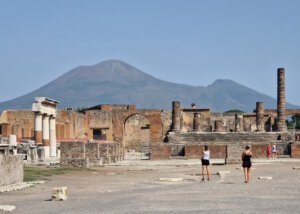 Die antiken Ruinen von Pompeji liegen still in der Sonne, während der Vesuv im Hintergrund über der Szene wacht. Der Anblick erinnert eindrucksvoll daran, wie eng die Geschichte dieser römischen Stadt mit der Kraft des Vulkans verbunden ist. (Foto: © Bastian Glumm)